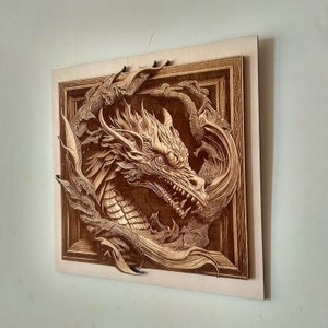 May include: A wooden wall art piece featuring a detailed carving of a dragon's head with intricate details. The dragon is framed in a wooden frame with a brown finish.