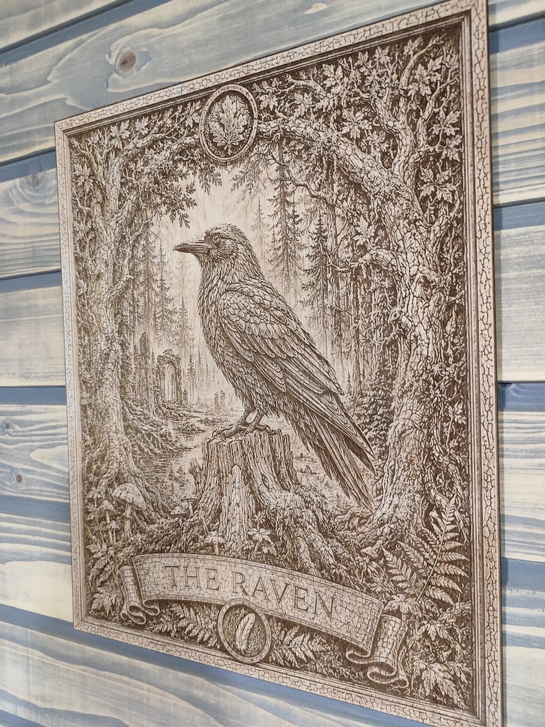 May include: A rectangular wooden wall plaque featuring a detailed laser-engraved illustration of a raven perched on a tree stump within a forest. The artwork includes an arched stone structure in the background and a banner at the bottom with the text THE RAVEN.