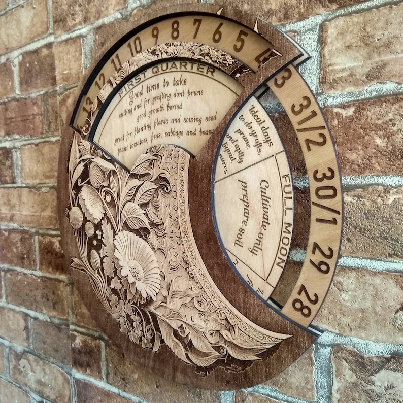 Peut inclure: Un calendrier circulaire en bois avec un motif floral et les mots "Premier trimestre" et "Pleine lune". Le calendrier comporte les num&eacute;ros de 1 &agrave; 31 et le texte "Jours id&eacute;aux pour faire des greffes. Tailler et appliquer des rem&egrave;des liquides. Cultiver uniquement pr&eacute;parer le sol."