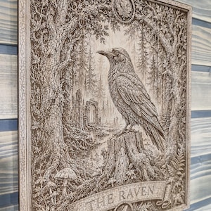 May include: A rectangular wooden wall plaque featuring a detailed laser-engraved illustration of a raven perched on a tree stump in a forest. The artwork includes trees, foliage, mushrooms, and a stone archway. The text THE RAVEN is engraved below.