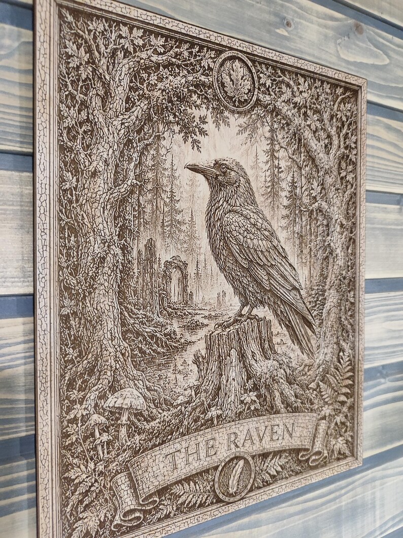May include: A rectangular wooden wall plaque featuring a detailed laser-engraved illustration of a raven perched on a tree stump in a forest. The artwork includes trees, foliage, mushrooms, and a stone archway. The text THE RAVEN is engraved below.