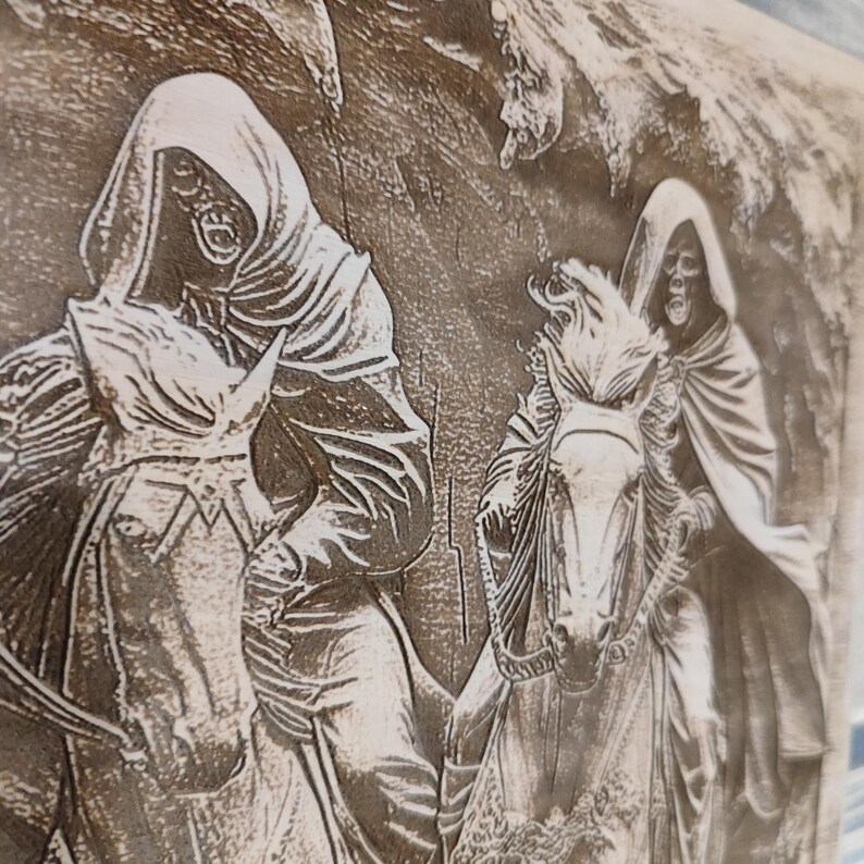 May include: A detailed wood carving depicts two figures in hooded cloaks riding horses. The figures have skeletal faces and are set against a textured background. The carving is in shades of brown and gray, creating a gothic or fantasy theme.