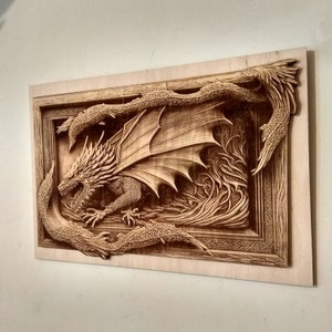 May include: A wooden wall art sculpture of a dragon with its wings spread wide. The dragon is carved in intricate detail and is surrounded by a frame of swirling vines.