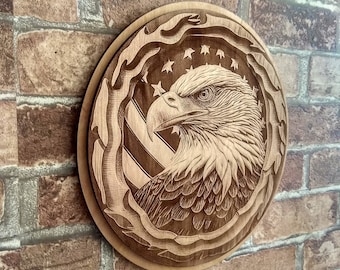 May include: A wooden wall plaque with a carved image of a bald eagle with its wings spread, looking to the right. The eagle is surrounded by a carved design of an American flag with stars and stripes.