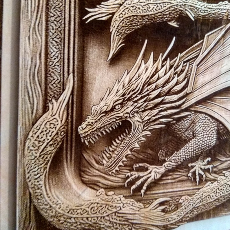 May include: A detailed wood carving of a dragon with its mouth open, showing sharp teeth. The dragon is in a frame with intricate carvings around the edges.