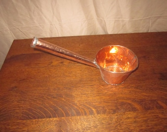 Cucharón antiguo de cobre con mango reparado.