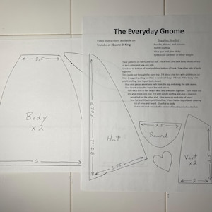 May include: A black and white line drawing pattern for a gnome. The pattern includes instructions for making a body, hat, beard, and vest. The text "The Everyday Gnome" is at the top of the page.