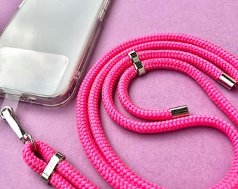 May include: A bright pink phone strap with silver hardware. The strap is made of a thick, braided cord and is long enough to wear around the neck.