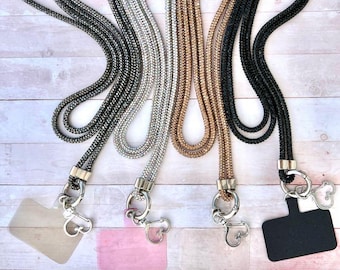 May include: Four different beaded lanyards with silver clasps and clear, pink, and black badge holders. The lanyards are black, silver, gold, and iridescent.