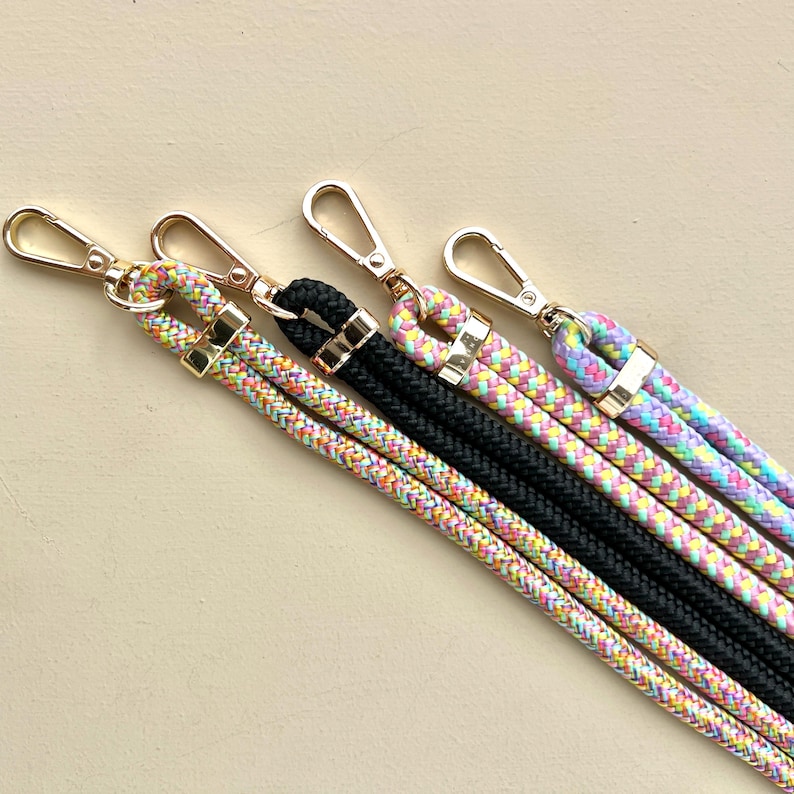 Puede incluir: Cuatro correas de tel&eacute;fono de cuerda trenzada de colores con cierres dorados. Las correas son de color rosa, amarillo, verde y azul.
