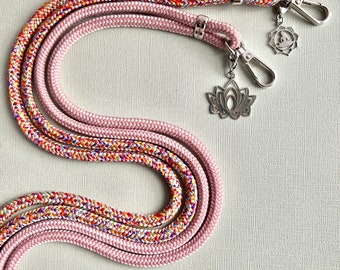 May include: Two pink and multi-colored rope lanyards with silver lotus flower and sun charm pendants.