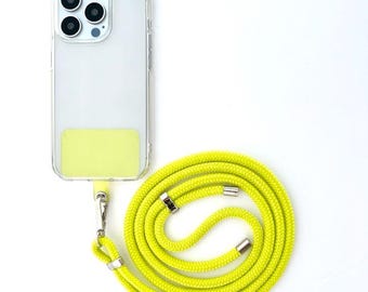 May include: A clear phone case with a bright yellow phone strap. The phone case has a clear back and a yellow accent on the bottom. The phone strap is made of a thick, braided cord.