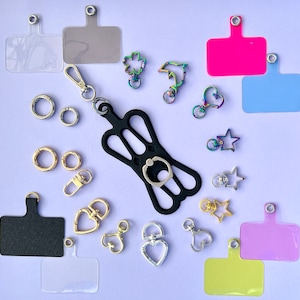 Puede incluir: Surtido de llaveros y dijes coloridos, que incluyen un soporte para anillo de teléfono, un delfín, un corazón, una estrella y una variedad de otras formas. Los llaveros están hechos de metal y plástico y son perfectos para agregar un toque de personalidad a tus llaves o bolso.