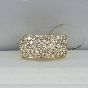 May include: A gold band ring with a wide, pave-set diamond band.