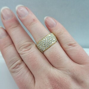 May include: A gold band ring with a wide band set with small diamonds.