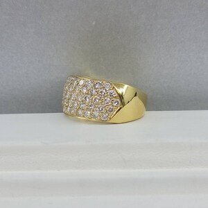 May include: A gold ring with a wide band set with small diamonds.