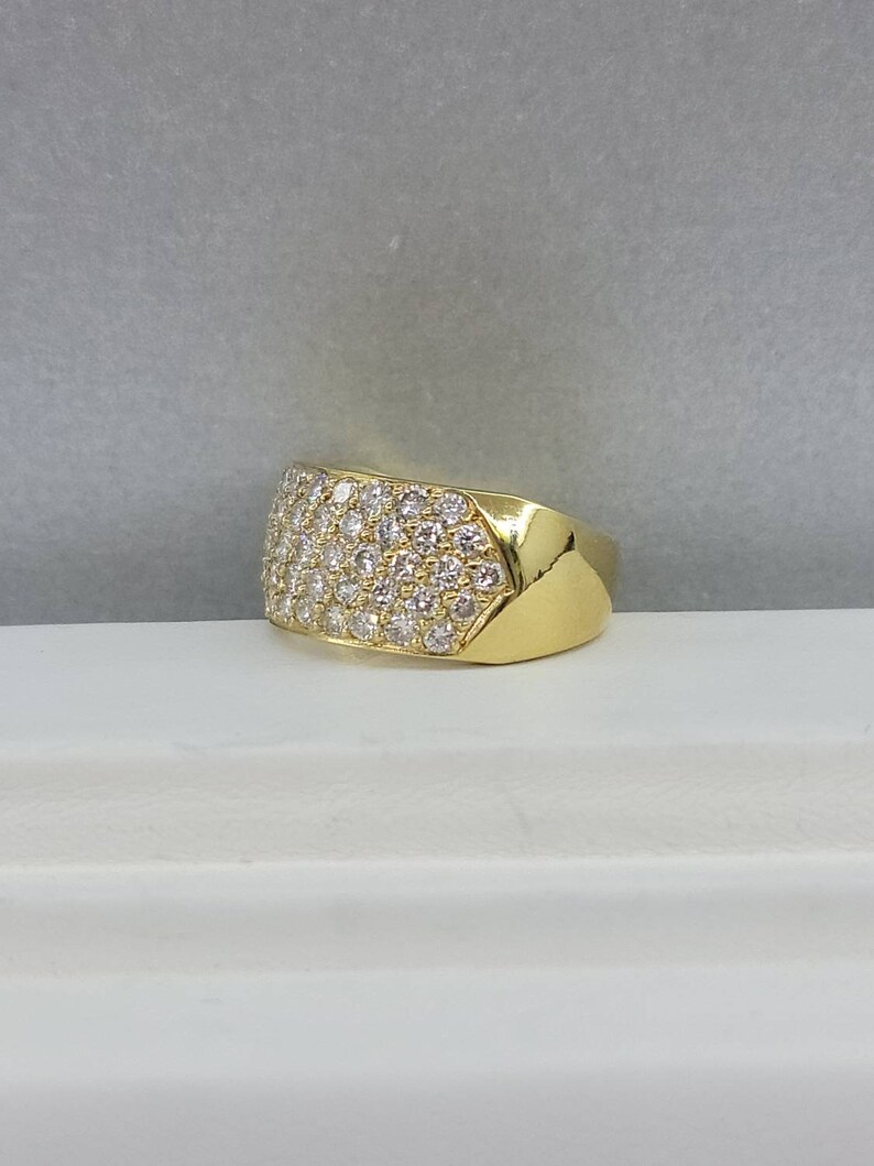 May include: A gold ring with a wide band set with small diamonds.