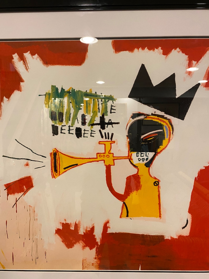 May include: Abstract artwork depicting a yellow figure playing a trumpet, with a black crown and a white background with red and white brushstrokes. The art has a bold, graphic style.