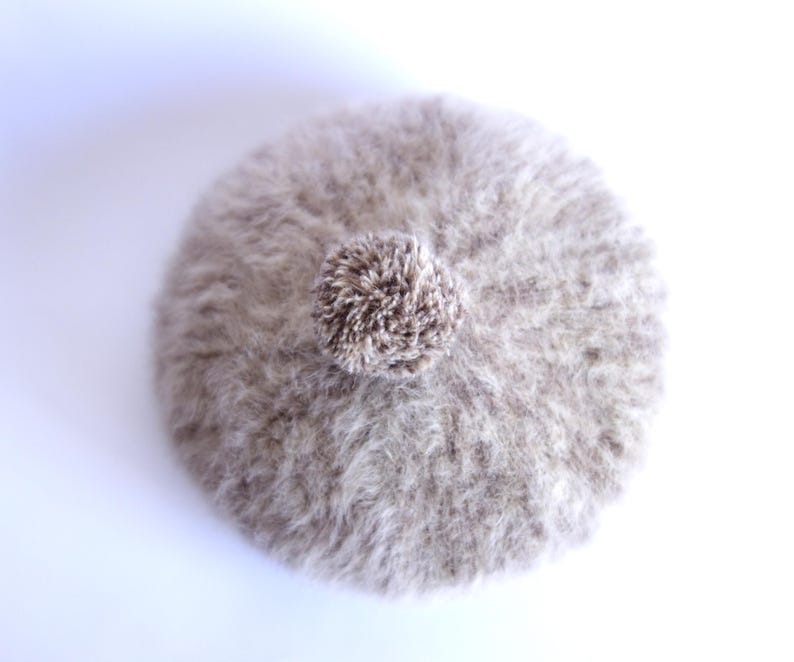 May include: A set of three ceramic mugs with a speckled, cream-colored glaze. Each mug features a different hand-painted floral design in shades of blue, green, and yellow. The mugs have a simple, rounded shape and a comfortable handle.