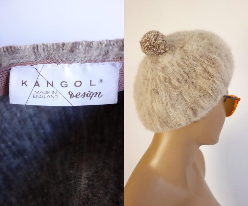 May include: A beige, fuzzy Kangol design hat with a pom-pom on top. The hat is paired with orange-tinted sunglasses. The label reads "KANGOL design MADE IN ENGLAND".