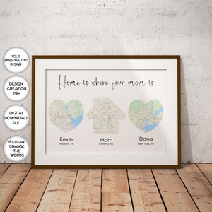 Puede incluir: Impresión enmarcada con el texto "Home is where your mom is". La obra presenta diseños de mapas en forma de corazón y casa, con nombres y ubicaciones debajo. El marco es marrón.