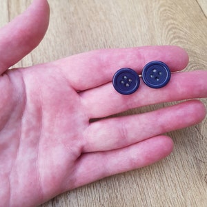 May include: Two dark blue buttons with four holes each.