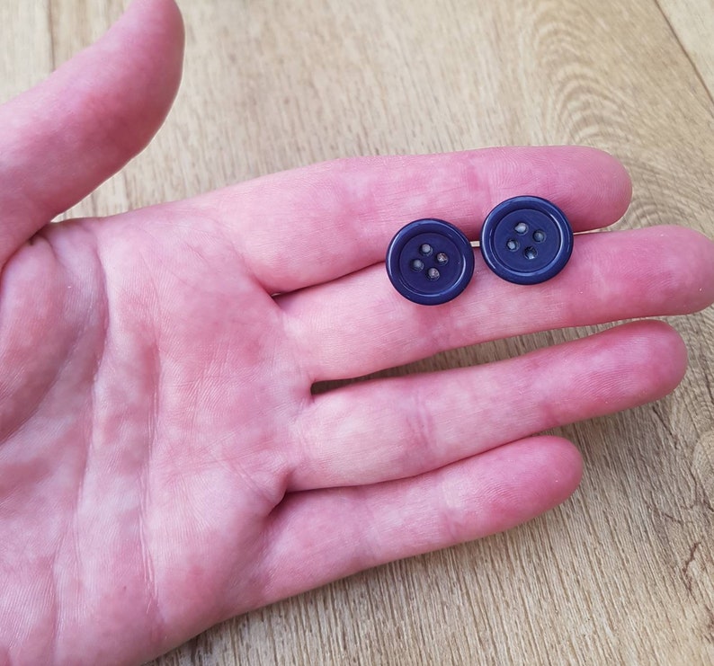 May include: Two dark blue buttons with four holes each.
