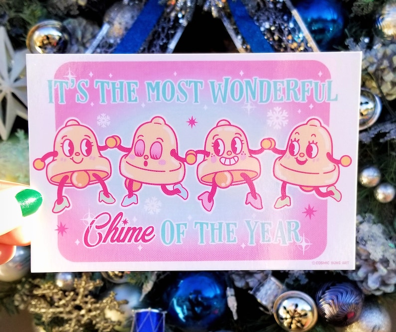 May include: A pink and blue Christmas card with four cartoon bells holding hands. The card reads "It's the most wonderful Chime of the Year".