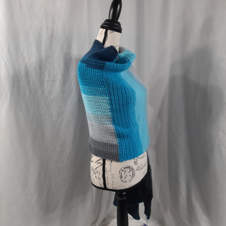 K&ouml;nnte beinhalten: Ein blauer und grauer H&auml;kel-Kragen mit einem Rollkragen. Der Kragen ist aus einem Farbverlaufsgarn gefertigt, das von Grau zu Blau &uuml;bergeht.