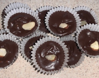 Una docena de racimos de almendras con chocolate negro sin azúcar, aptos para dietas cetogénicas.