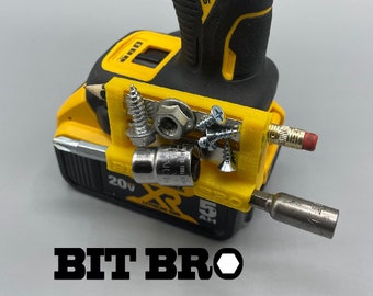 May include: A yellow and black cordless drill with a 3D printed accessory attached to the side. The accessory is a bit holder with a variety of bits and screws attached to it. The text "BIT BRO" is printed in black letters below the drill.