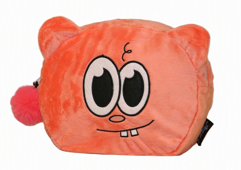 Op de afbeelding: Een oranje pluche etui met een cartoongezicht met grote witte ogen, zwarte pupillen, een kleine neus en twee zichtbare tanden. Het etui heeft afgeronde oren en een felroze pompon bevestigd aan de ritssluiting aan de zijkant.