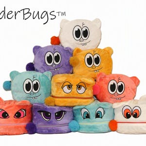 May include: A pyramid stack of plush BedderBugs toys in various colors including white, purple, orange, teal, and pink. Each soft square-shaped toy features embroidered cartoon eyes, mouths, and small pom-pom accents on the sides and corners.