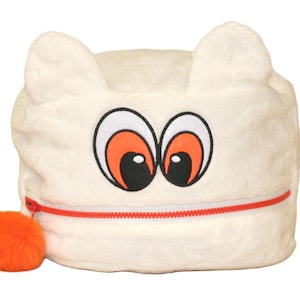 Op de afbeelding: Een wit pluche tasje met twee puntige oren aan de bovenkant en een cartoongezicht met grote witte en oranje ogen. Het tasje heeft een horizontale rode ritssluiting aan de voorkant, afgewerkt met een ronde, pluizige oranje pompon als trekker.