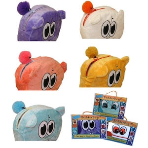 Op de afbeelding: Een collectie pluche BedderBugs opbergtassen in paars, wit, roze, geel en lichtblauw. Elke tas heeft een cartoongezicht met grote ogen, een ritssluiting en een pluizige pompon. Drie tassen worden getoond in hun originele verpakking.