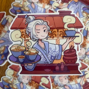 Puede incluir: Una persona de cabello blanco que lleva una túnica azul y blanca se encuentra detrás de un mostrador con un techo rojo. Lleva una bandeja con cuatro cuencos de fideos humeantes y una taza pequeña. El mostrador tiene un techo rojo y un letrero que dice "Ramen".