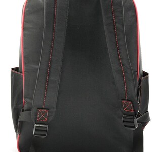 Puede incluir: Mochila negra con costuras rojas y correas ajustables. La mochila tiene un bolsillo con cremallera en la parte delantera.