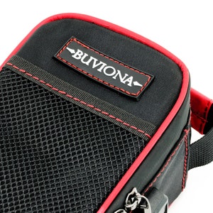 May include: Black zippered pouch with a red trim and a mesh pocket. The pouch has a red label with the text "BUVIONA" in white.