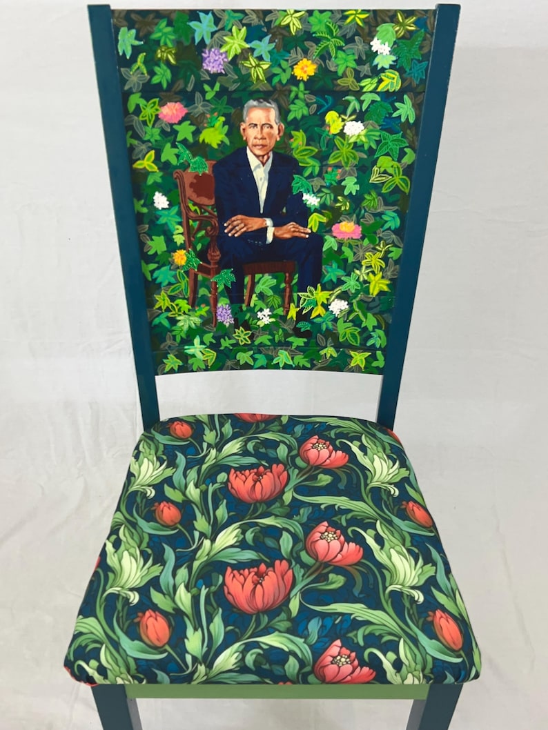 Puede incluir: Una silla azul verdosa con un respaldo de estampado floral verde y blanco y un asiento azul oscuro con estampado floral rojo.
