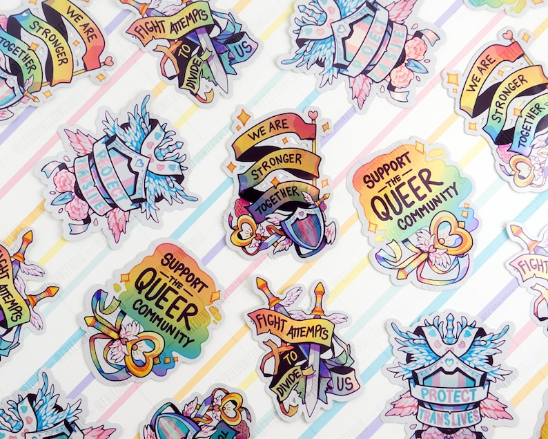 May include: A set of colourful stickers with rainbow designs and messages of support for the LGBTQ+ community. The stickers feature phrases like "We are stronger together", "Support the Queer Community", and "Fight attempts to divide us".