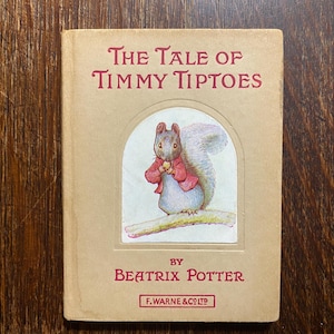 May include: A vintage copy of "The Tale of Timmy Tiptoes" by Beatrix Potter. The book has a tan cover with red lettering and a colour illustration of a squirrel holding a nut. The book is from F. Warne & Co Ltd.