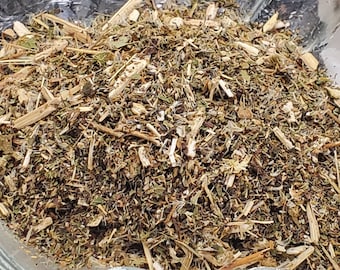 May include: A clear glass dish filled with dried herbs. The herbs are a mix of green, brown, and tan, with visible stems and leaves. The dish is sitting on a white surface.