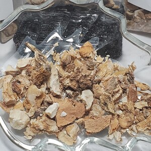 A top-down, close-up shot of a clear, leaf-shaped glass bowl filled with dried Solomon's Seal Root. The image highlights the natural, earthy cream and tan colors of the fibrous, chopped root pieces, emphasizing the high quality of the organic botanical.