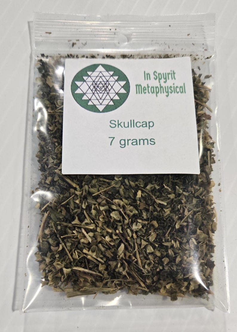 A clear plastic ritual bag containing 7 grams of dried organic Skullcap Leaf from In Spyrit Metaphysical, featuring the shop's logo and clearly labeled with the weight.