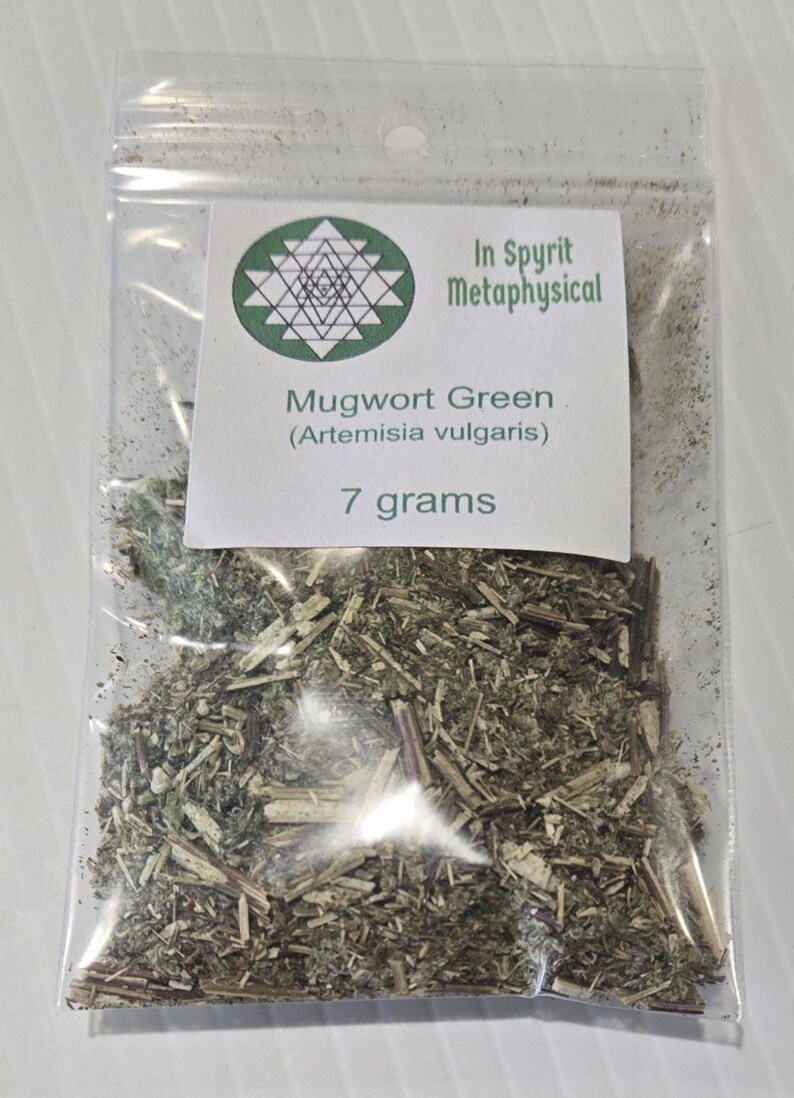 Close-up of a clear resealable bag containing 7 grams of dried Mugwort Green (Artemisia vulgaris). The label features the InSpyrit Metaphysical Sri Yantra sacred geometry logo, representing the union of Divine Masculine and Feminine.
