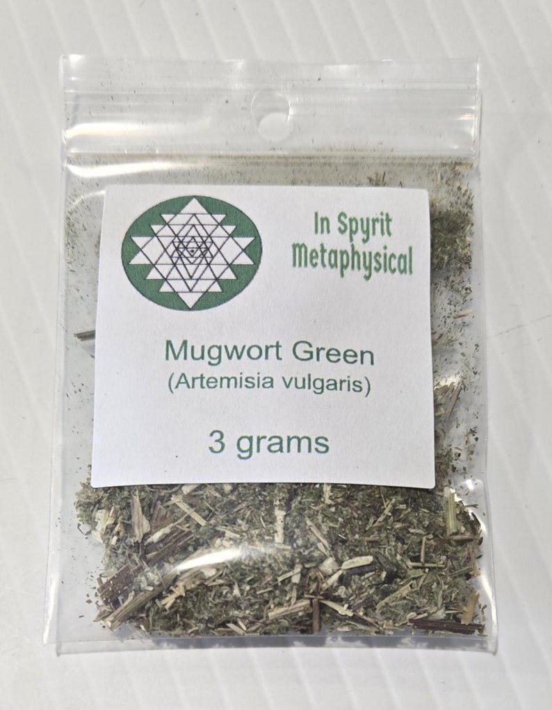Close-up of a clear resealable bag containing 3 grams of dried Mugwort Green (Artemisia vulgaris). The white label features the InSpyrit Metaphysical star logo and the botanical name, showing the silver-green texture of the ritual herb.