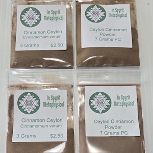 May include: Four small, clear plastic bags filled with brown powder, each with a white label. The labels read "In Spyrit Metaphysical" and list the contents as "Cinnamon Ceylon" or "Ceylon Cinnamon Powder" with the weight in grams.