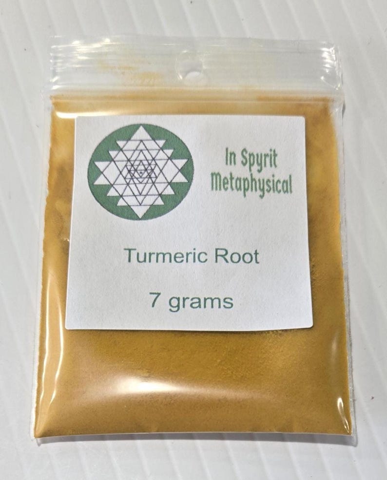 Close-up of a 7 gram bag of InSpyrit Metaphysical Turmeric Powder, showing the vibrant golden-yellow ground root and the professional white branded label.