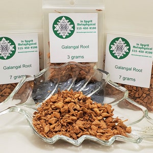 Peut inclure: Racine de galanga, une &eacute;pice, pr&eacute;sent&eacute;e dans un plat transparent en forme de feuille et dans trois petits sachets en plastique. Les sachets sont &eacute;tiquet&eacute;s avec le texte "Galangal Root" et des poids de 3 et 7 grammes. Les sachets incluent &eacute;galement un logo et des coordonn&eacute;es.
