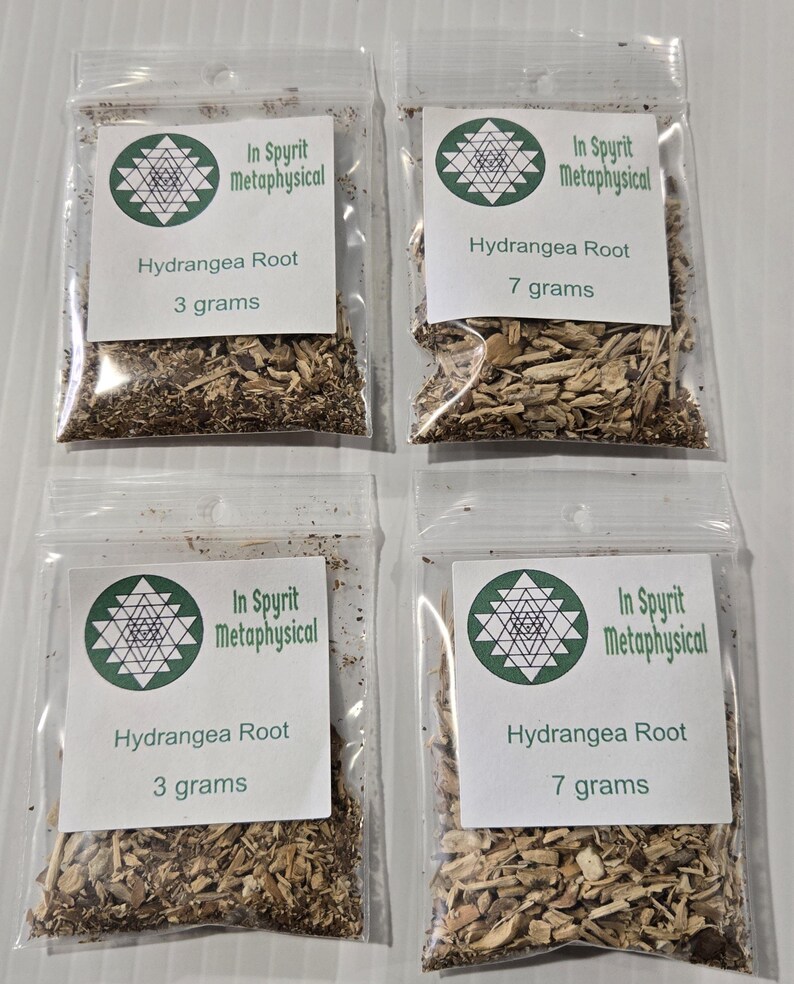 A product display photograph from InSpyrit Metaphysical showing four clear plastic bags of dried hydrangea root arranged in a grid, featuring two 3-gram sample bags on the left and two 7-gram standard bags on the right, all labeled with company branding.